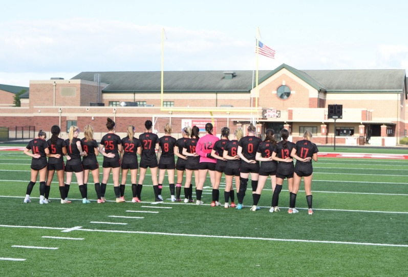 Girls varsity soccer lining up for the National Anthem 2024